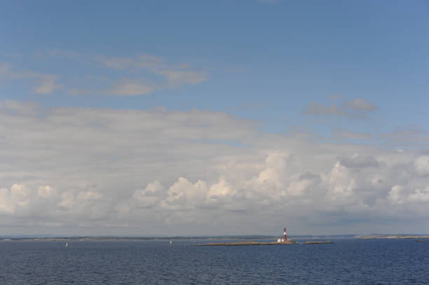 istock Lighthouse on a tiny uninhabited island in Skagerrak Strait between  Sweden and Norway on a sunny day with blue sky, navy blue sea and white clouds 1339448023