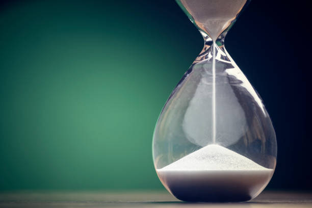 Hourglass time passing background concept for business deadline, urgency and running out of time Hourglass time passing green background concept for business deadline, urgency and running out of time hourglass stock pictures, royalty-free photos & images
