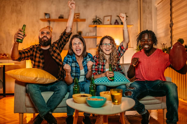 excited fans cheering for sport team watching american football game - american football football food snack imagens e fotografias de stock