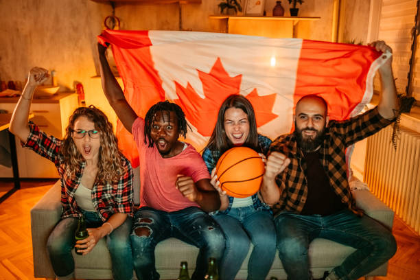 aufgeregte kanadische fans jubeln der sportmannschaft zu, die das basketballspiel sieht - canadian flag fotos stock-fotos und bilder