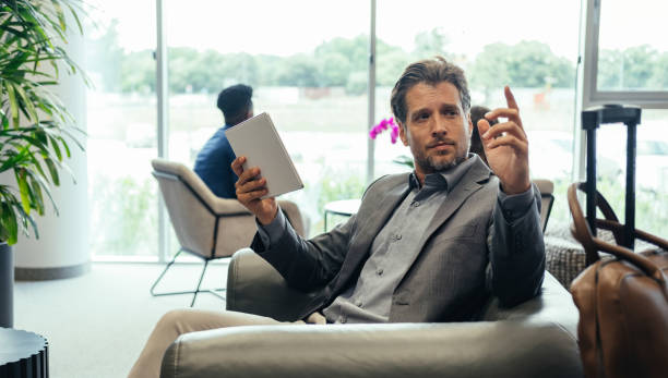 istock Businessman Using Digital Tablet while Waiting for his Flight in the Business Lounge 1339451585