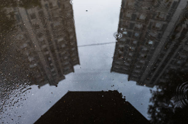istock Blurred reflection on wet city sidewalk on rainy day 1339452829