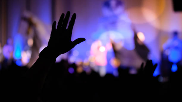 manos levantando concierto, manos levantando por antecedentes religiosos - rezar fotos fotografías e imágenes de stock
