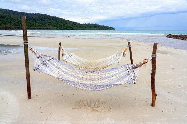 istock Blue hammocks on the sand beach with sea and sky 1339453525