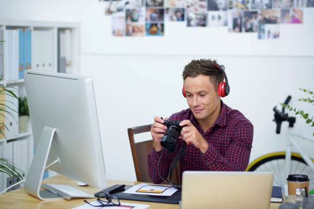 istock Smiling Photographer Sitting at Office Desk 1339455829