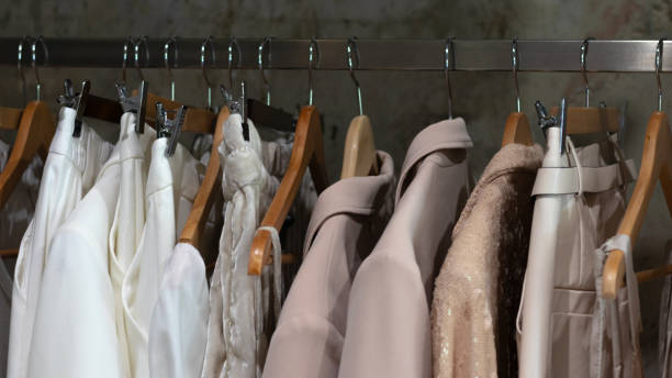 istock White beige range of clothes hangs on hangers in boutique 1339458177