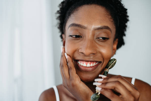 istock Skin care black woman Using Jade Facial Rollers 1339458936