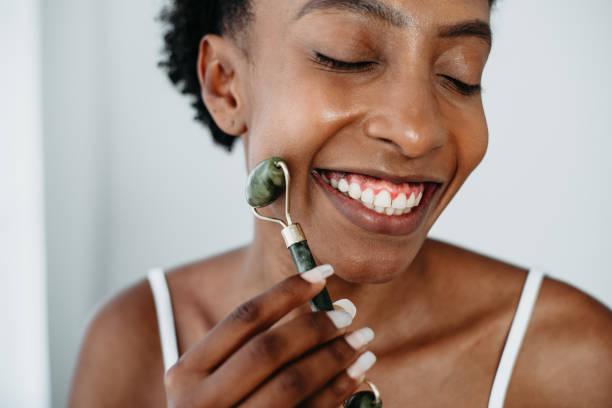 istock Skin care black woman Using Jade Facial Rollers 1339458937