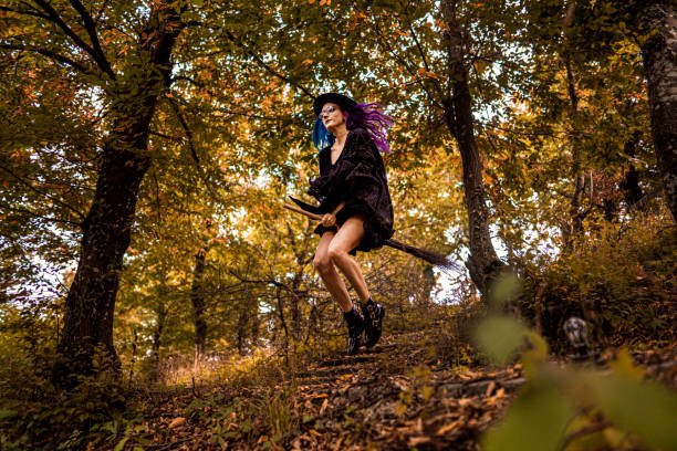 istock Young witch flies on a broom through the forest 1339459582