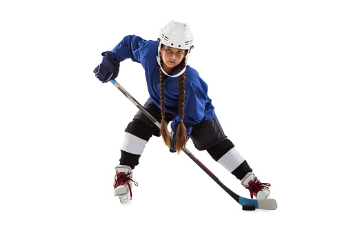 Shot on goal, stickhandling. Full-length portrait of young girl playing hockey. Child holding stick, wearing helmet. Competition training. Winning goals. Concepth of childhood, sport, strength ad