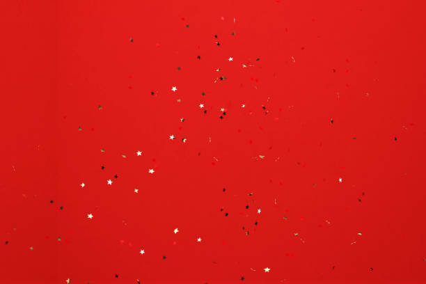 istock Star Shaped Gold Colored Confetti Falling over Red Background 1339463159