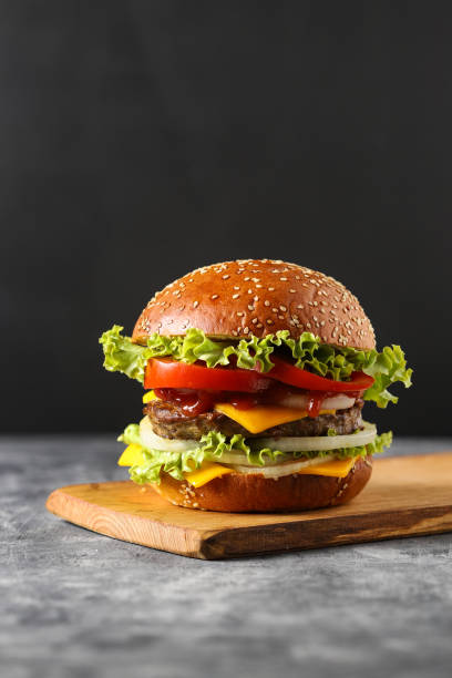 sabrosa hamburguesa con queso de comida rápida sobre fondo negro - sandwich turkey gourmet fast food fotografías e imágenes de stock