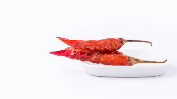 dried red chili peppers on a white tray, closeup dried red chili or cayenne peppers on a white tray, closeup of hot spice isolated on white background relieves stock pictures, royalty-free photos & images