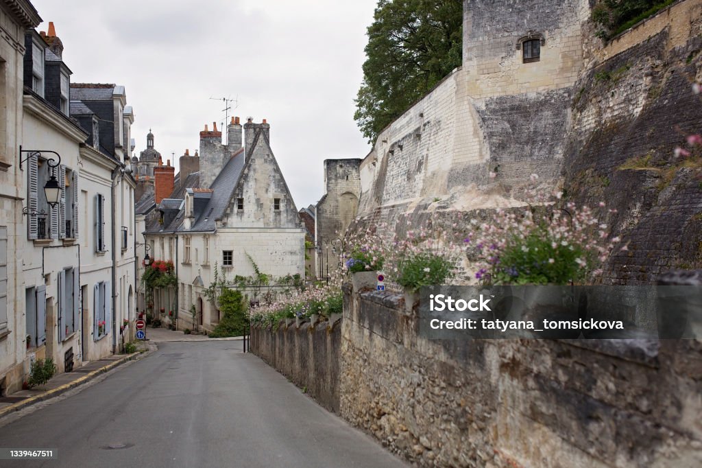 Beautiful small village street in France on a cloudy day Beautiful small village street in France on a cloudy day, focus on flowers Alley Stock Photo Beautiful small village street in France on a cloudy day Beautiful small village street in France on a cloudy day, focus on flowers Alley Stock Photo