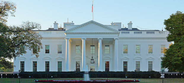 Daytime panoramic view of the northern facade of the white house featuring its classical portico with columns (Washington DC).