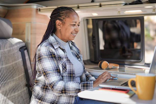 istock African senior woman working inside mini van camper with computer laptop - Digital nomand concept 1339472378