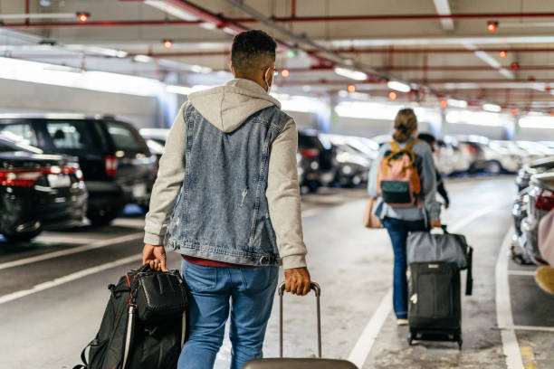 Passengers carrying bags in the airport parking lot stock photo