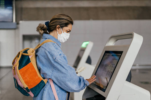 istock Woman wearing mask at self-service check-in. 1339473977