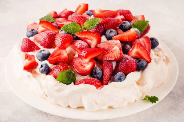 Delicious Pavlova cake with fresh strawberry and blueberry, selective focus
