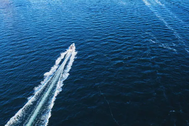 Aerial drone view of a power boat on the ocean.