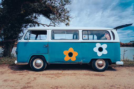 Vintage blue hippie Volkswagen van with flowers at Gola del Ter beach in Torroella de Montgrí on May 2nd 2021