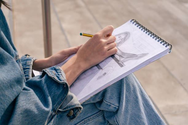 istock Close-up of a young woman's hands drawing with a black pencil. 1339484481