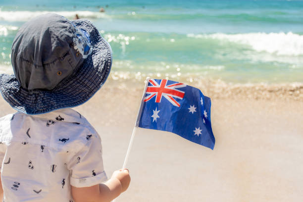 Little boy wearing hat holding Australian flag on a sandy ocean beach. Australia Day concept Little boy wearing hat holding Australian flag on a sandy ocean beach. Australia Day celebration concept western australia flag stock pictures, royalty-free photos & images