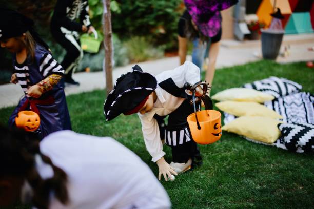 słodkie małe dzieci grające w halloweenową grę scavenger hunt na imprezie podwórkowej - scavenger hunt zdjęcia i obrazy z banku zdjęć