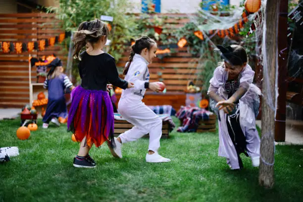 Photo of Group of happy kids or playing tag it game and running in the garden