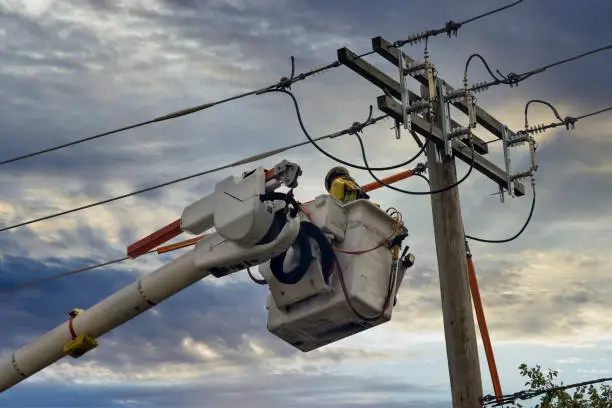 Engineering repair power lines working on high-voltage tower on after tornado