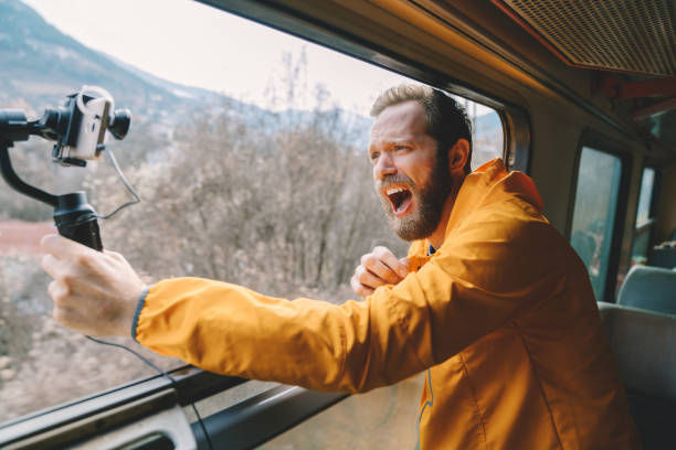 Man recording video for his blog while travelling in train