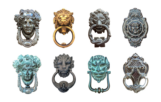 Set of isolated door knockers, gold lion head with the ring on its mouth, antique head and italian traditional doorknobs on white background.