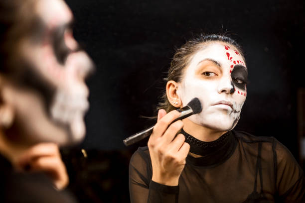 istock Face painting for Halloween night party looking at mirror getting ready 1339488485