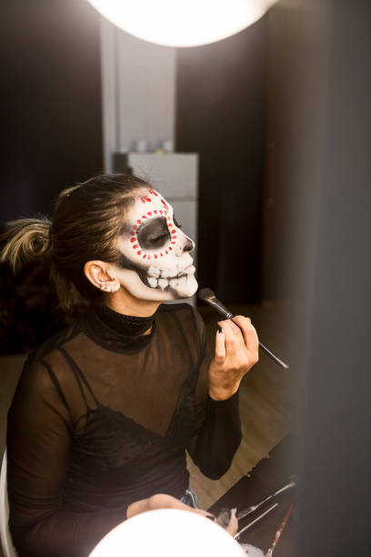 istock Face painting for Halloween party looking at mirror getting ready 1339488487