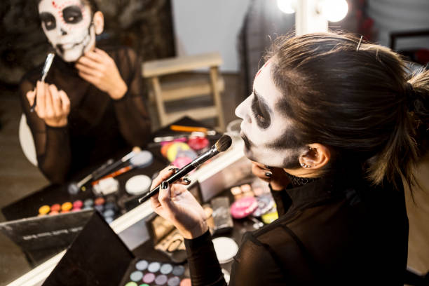 istock Face painting for Halloween night party looking at mirror 1339488519