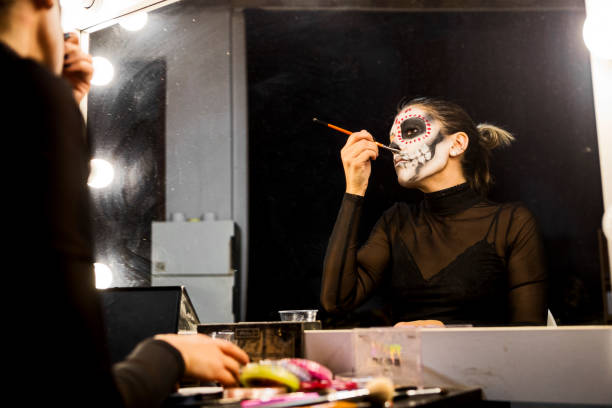 istock Face art painting for Halloween night party looking at mirror getting ready 1339488609