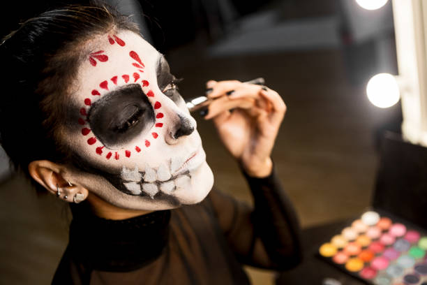 istock Mask Face painting for Halloween night party looking at mirror getting ready 1339488612