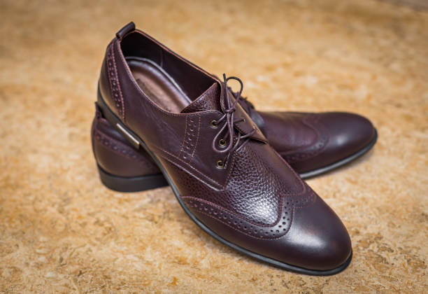 istock Closeup men's brown brogues on a beige background 1339489439
