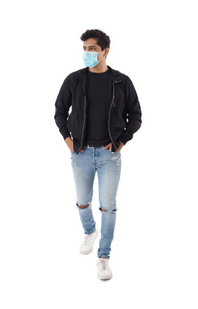 istock Young man with mask walking with hands in pockets 1339489481