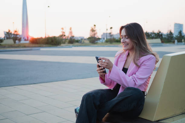 istock A beautiful laughing brunette uses a smartphone to communicate, 1339491096