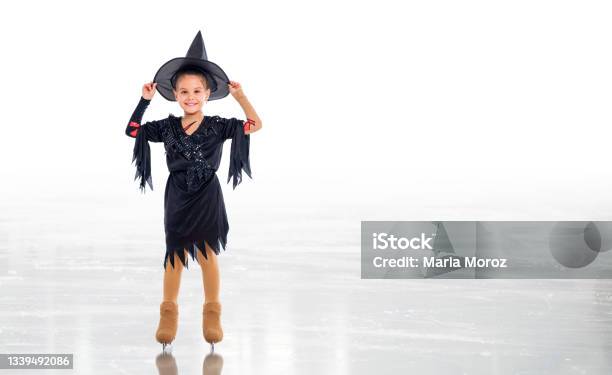 Little Young Skater Posing In Witch Costume For Halloween On Ice On White Background Stock Photo - Download Image Now
