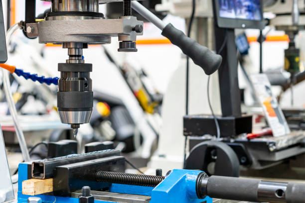 istock flow drill, or friction drilling tungsten carbide cutting tools hold by spindle collet chuck holder with square tube workpiece during hole making for thread tapping by vertical table drilling machine 1339507664