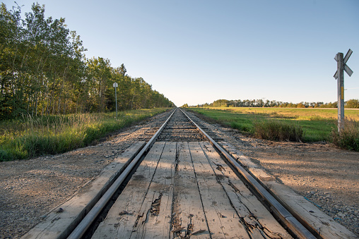 Railroad tracks at a crossing, in the early morning in rural Saskatchewan on the Canadian prairies.