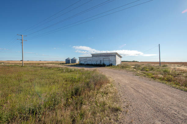 prédio abandonado na beira da estrada da pradaria. - saskatchewan country road road prairie - fotografias e filmes do acervo