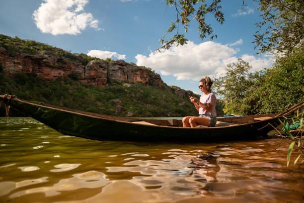 istock Woman using smartphone boat river bank 1339517429