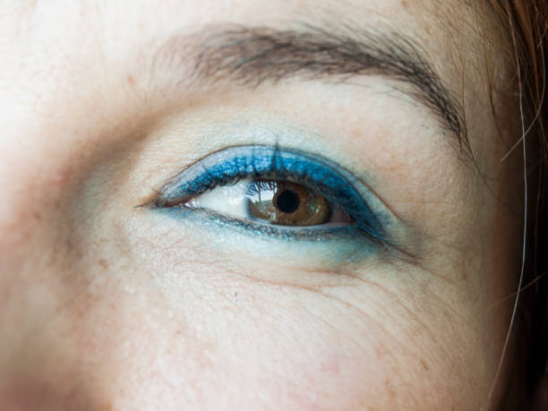 Close up shot of young woman doing a daily make-up routine in front of a mirror at her home bathroom before getting ready for going out