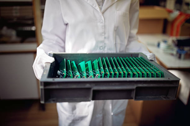 mujer sostiene placas de circuitos en una fábrica - african descent factory accuracy analyzing fotografías e imágenes de stock