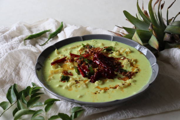 istock Pineapple pachadi. A yogurt based sweet and spicy curry made with pineapple, coconut, mustard seeds and curd. A side dish for Kerala meals 1339520578
