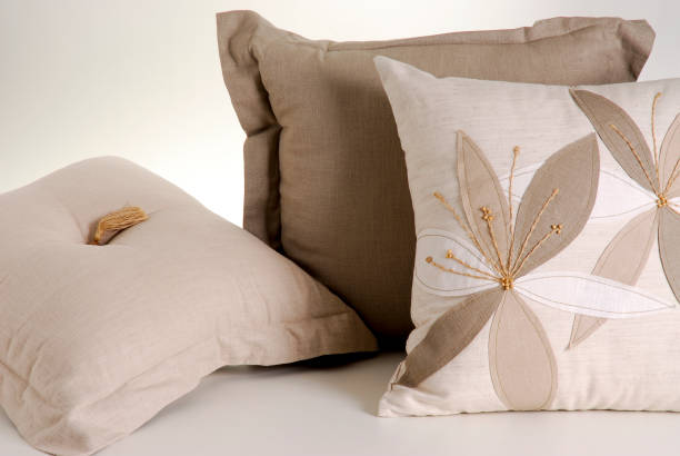 istock Three beige cushions. One of them has flowers pattern, isolated 1339520996