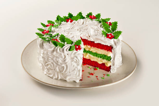pastel de navidad con capas coloridas, glaseado blanco y bayas de acebo, aislado - tarta de navidad fotografías e imágenes de stock